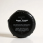 Shower steamer wrapped in black foil with product label sticker 