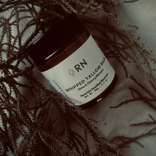 Whipped tallow balm with rimu leaf infusion, natural skincare product photographed on native New Zealand foliage.