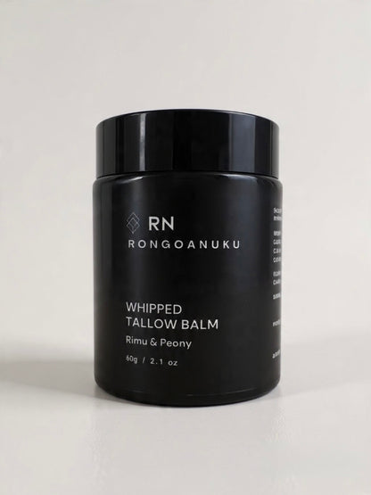 Black jar of Rongoanuku whipped tallow balm with rimu & peony on a light background