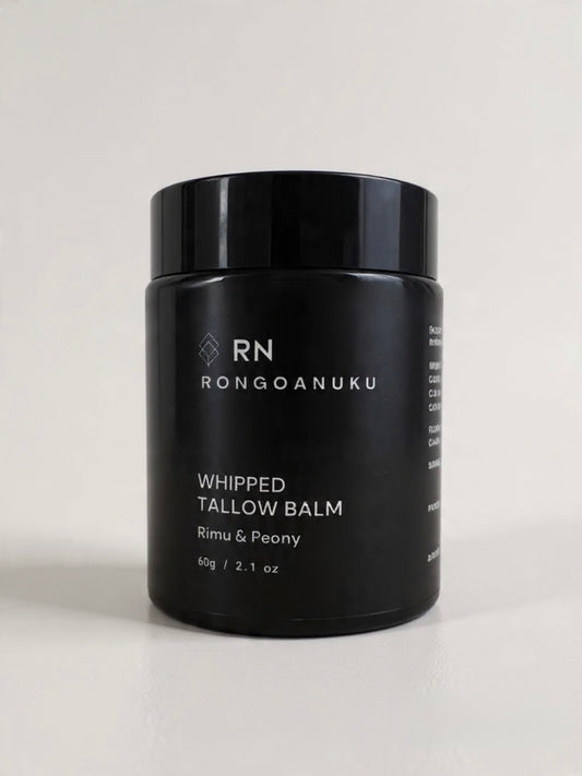Black jar of Rongoanuku whipped tallow balm with rimu & peony on a light background