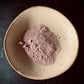 A mini bowl containing kawakawa and pink clay powder 