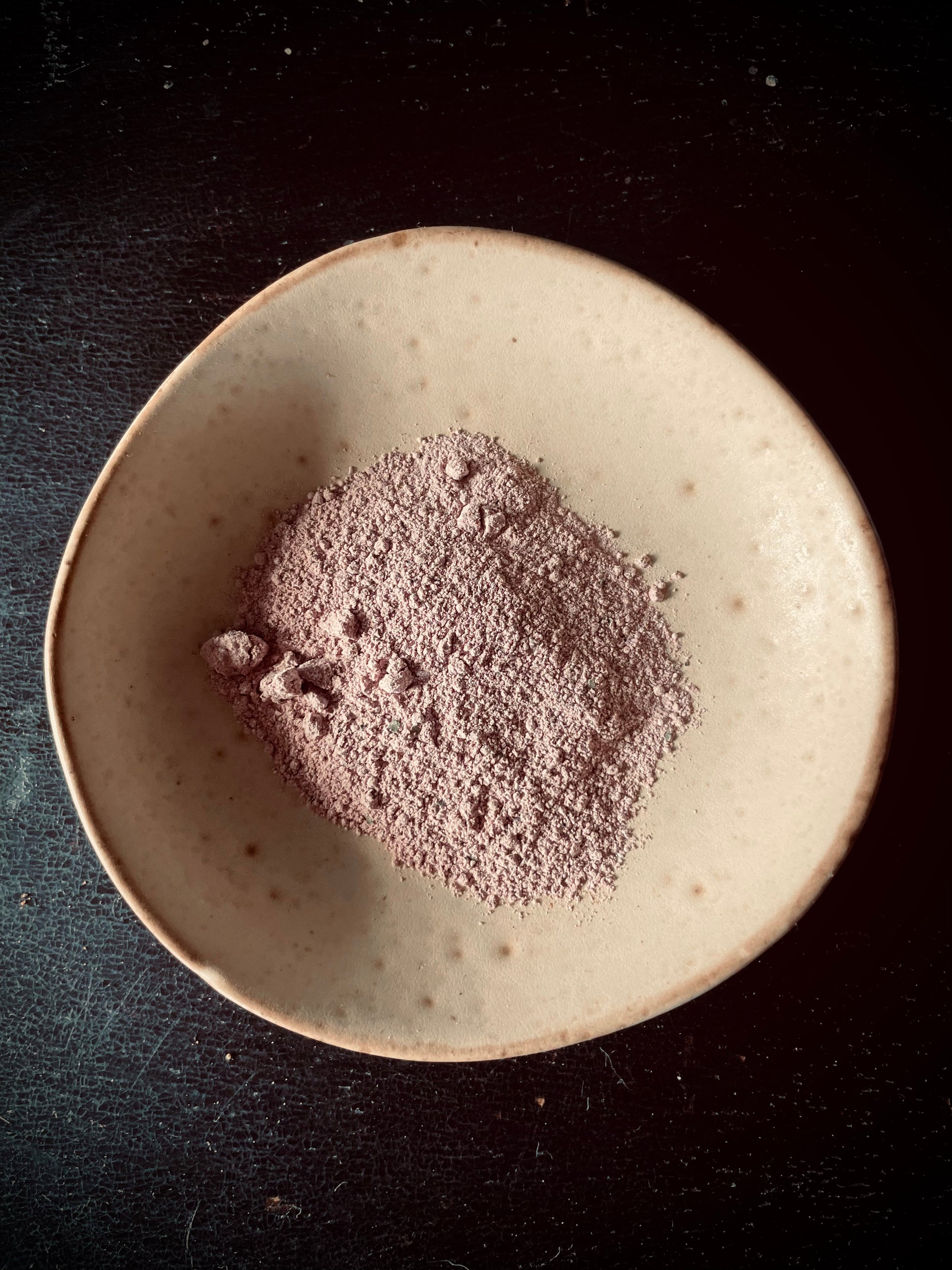 A mini bowl containing kawakawa and pink clay powder 